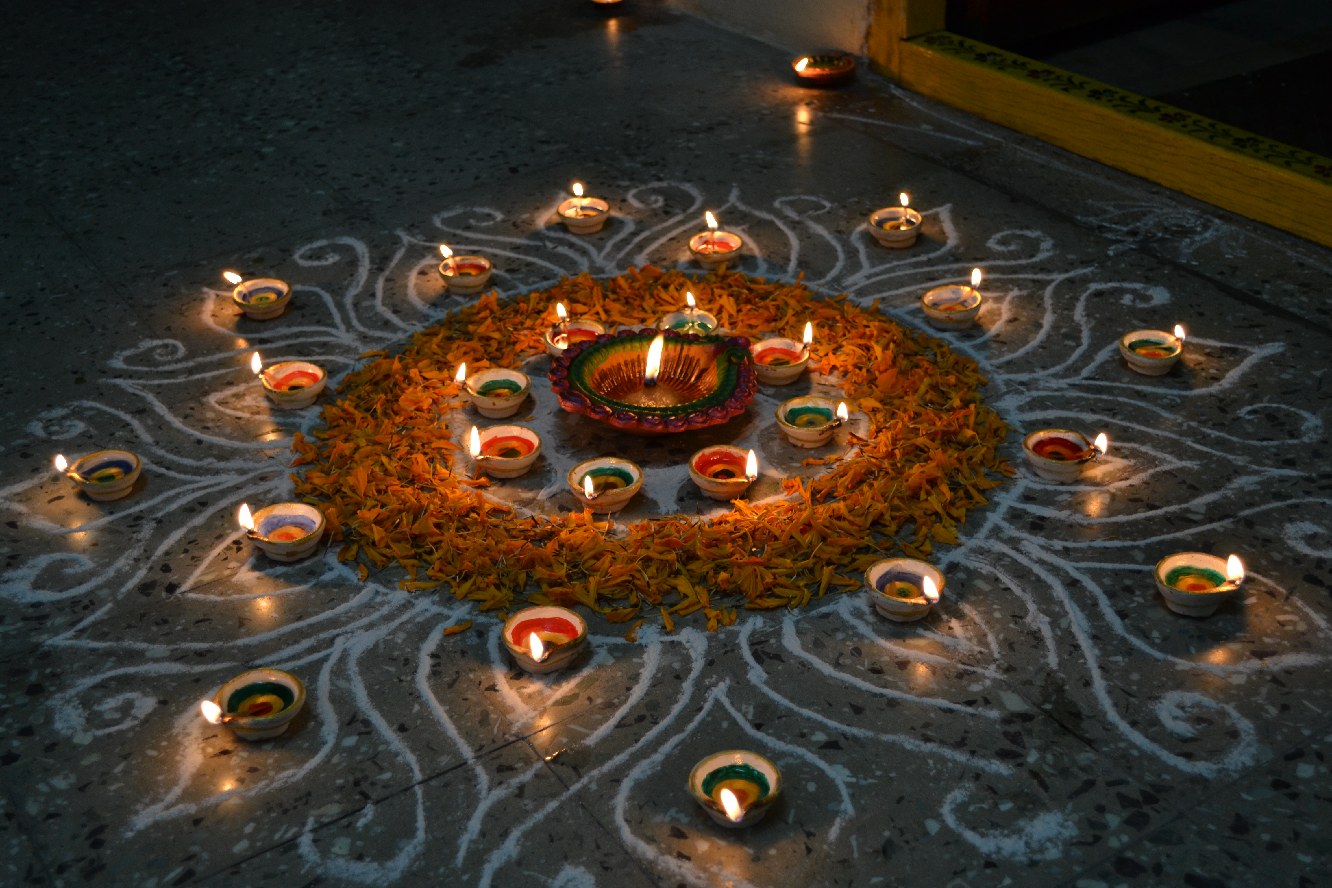 Sacred brass diya and floral rangoli in temple atmosphere